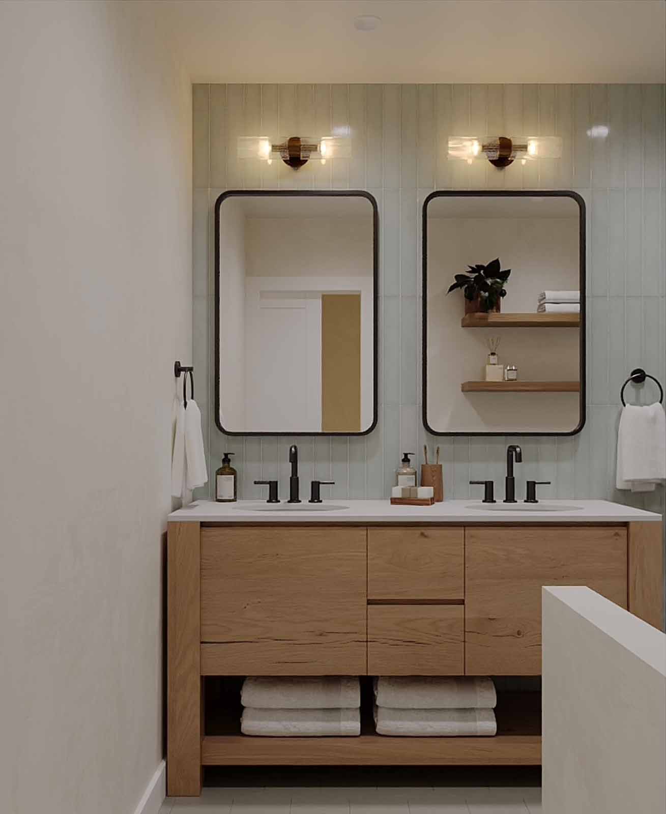 Contemporary bathroom with double mirrors, floating oak vanity, and sage subway tile