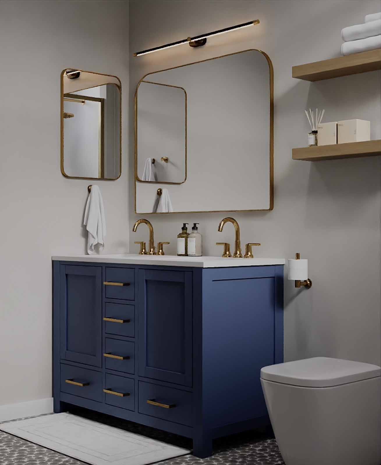 Double vanity bathroom with navy blue cabinet, asymmetric gold mirrors, and bar light