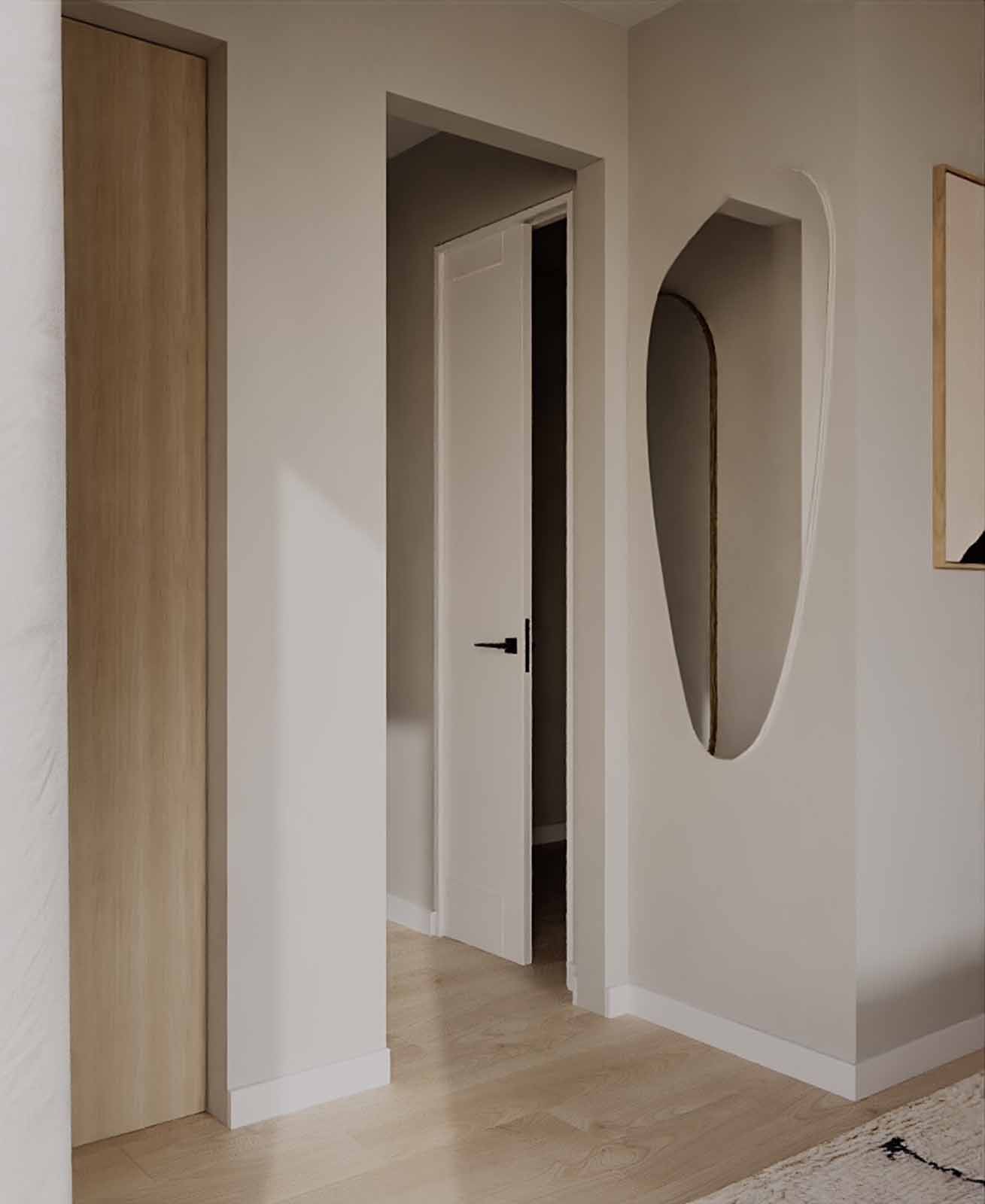 Minimalist entryway with organic shaped mirror, oak closet, and sculptural art niche