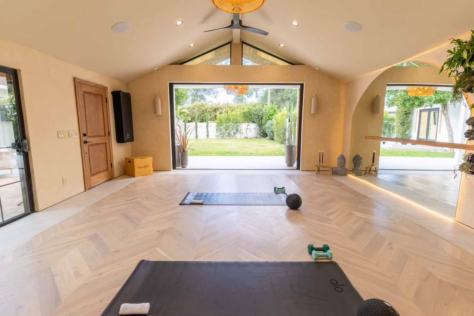 View from studio looking out to garden with yoga mat in foreground