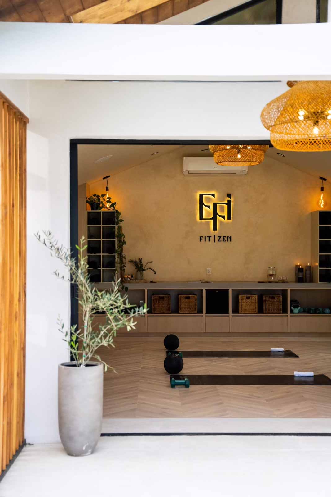 ADU entrance showing interior through glass doors with olive tree planter