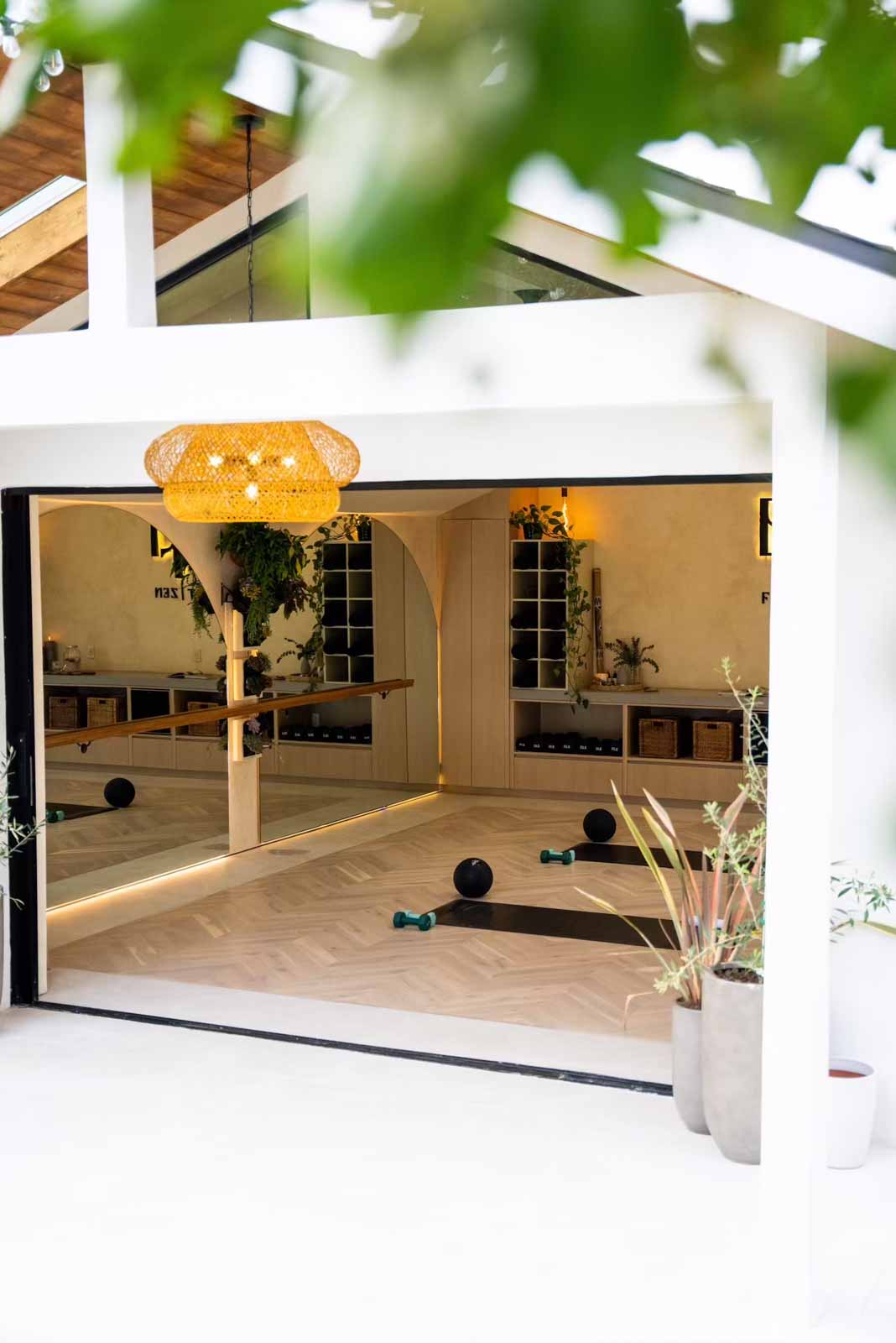 View into studio through open sliding doors with greenery in foreground