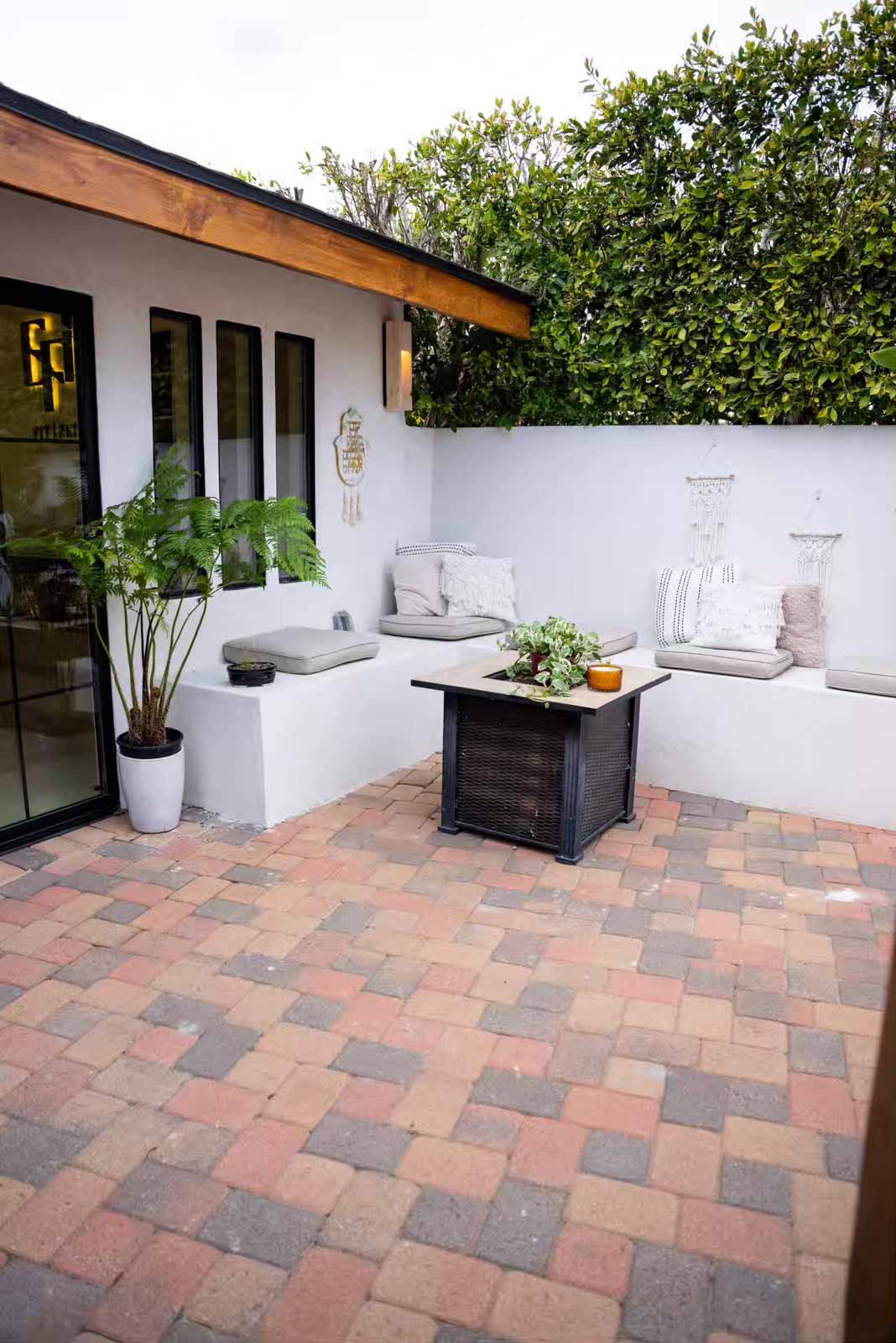 Patio area with built-in bench seating, cushions, and fire pit table