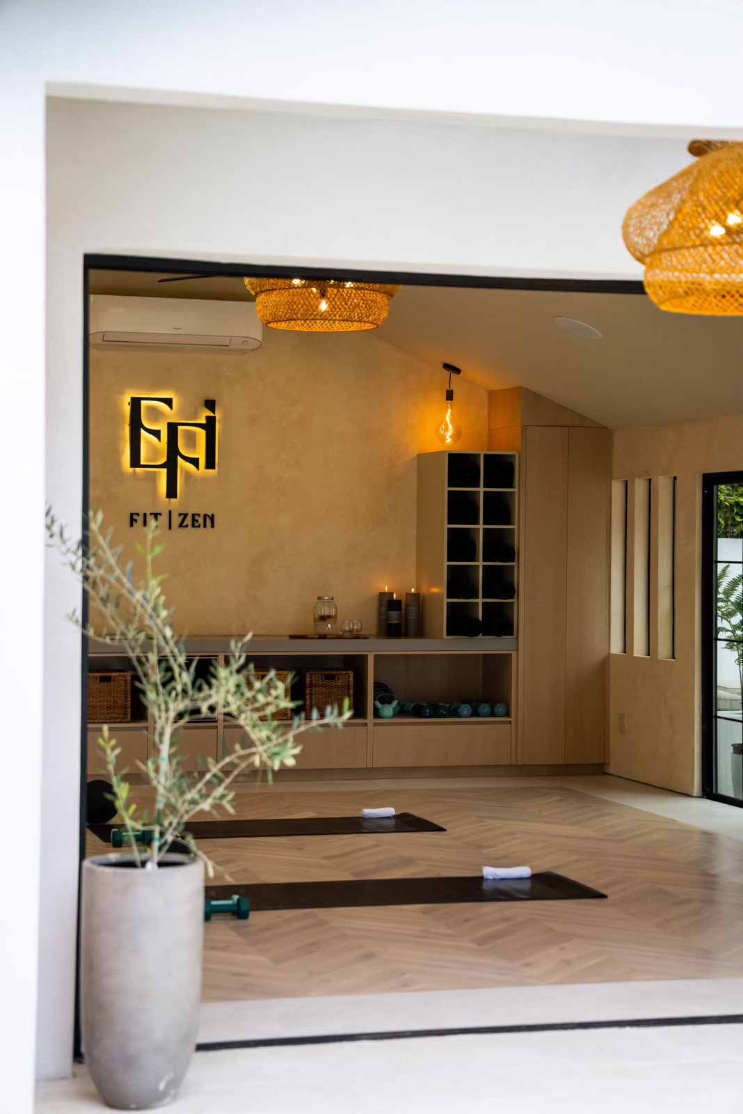 Studio entry framed by olive tree planters and rattan chandeliers