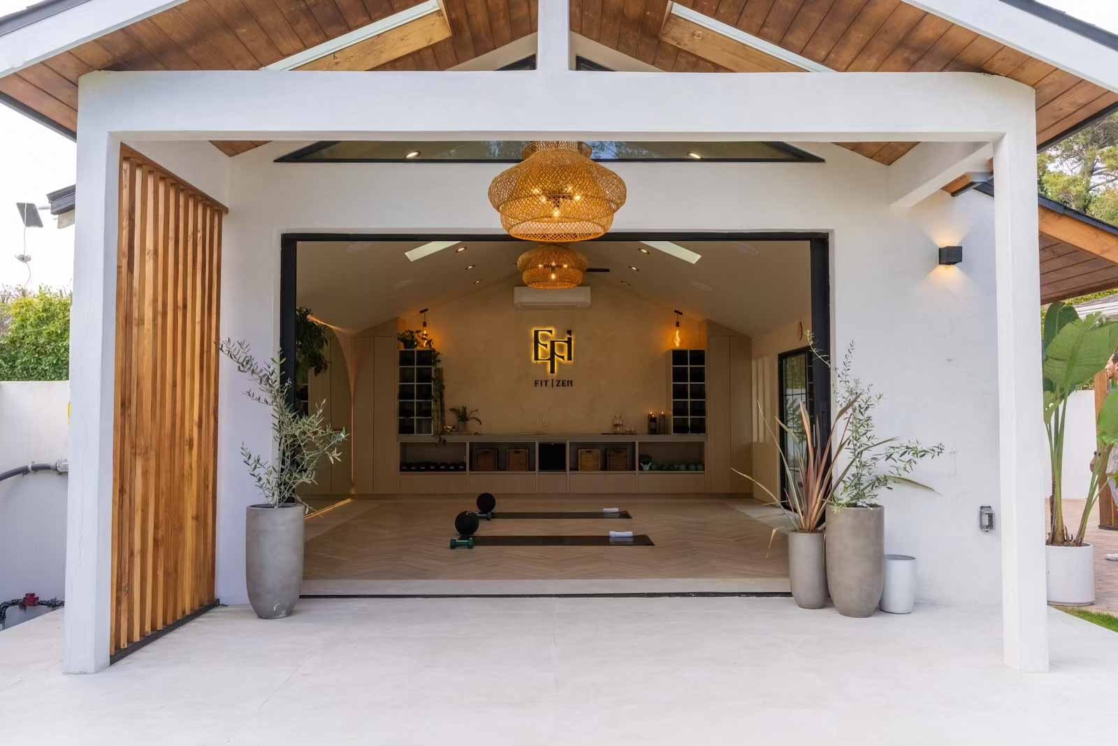 ADU covered entry with rattan pendant light, wood ceiling, and glass doors