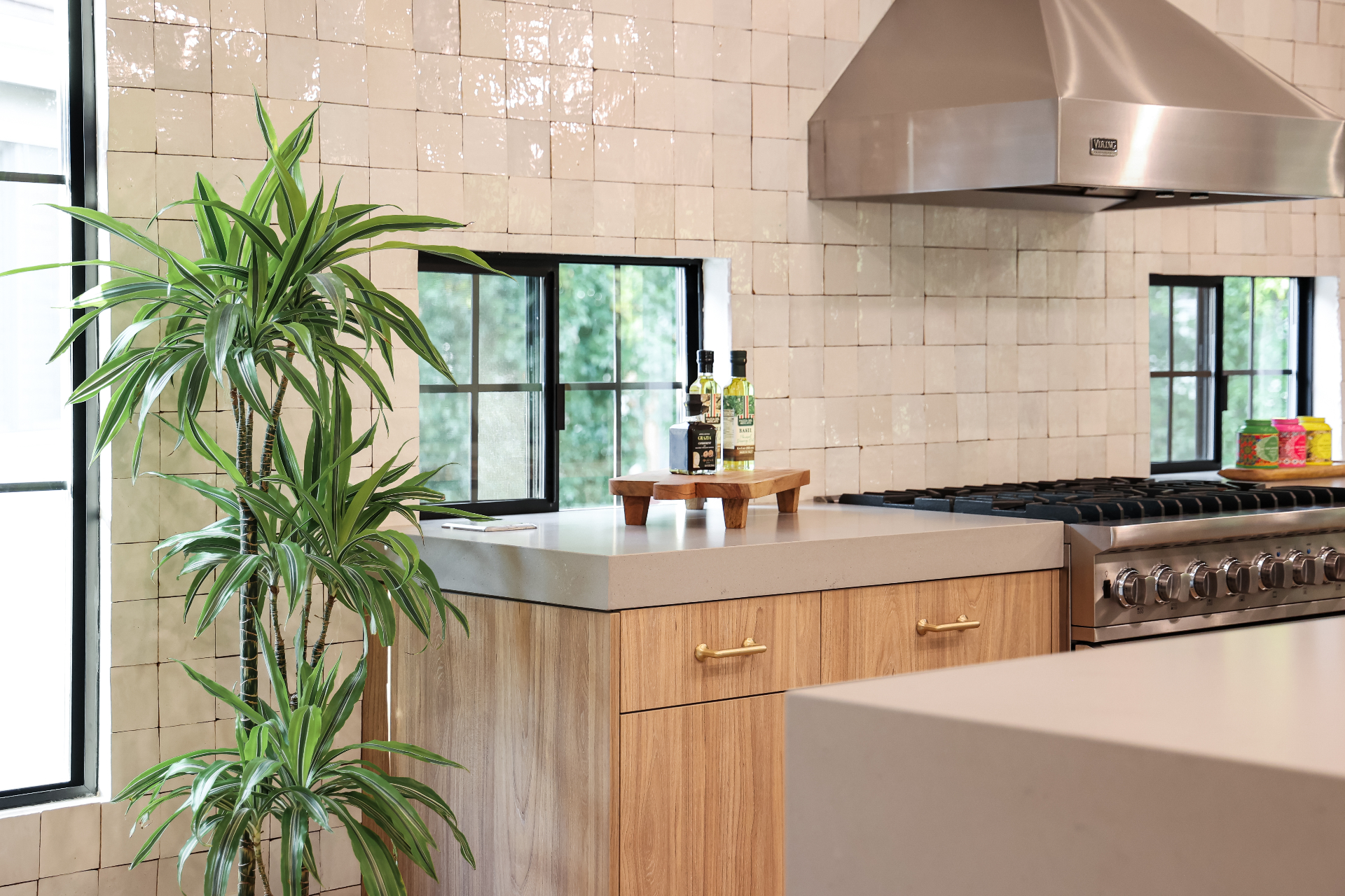 Professional gas range and stainless steel hood with custom tile backsplash in Los Angeles kitchen renovation