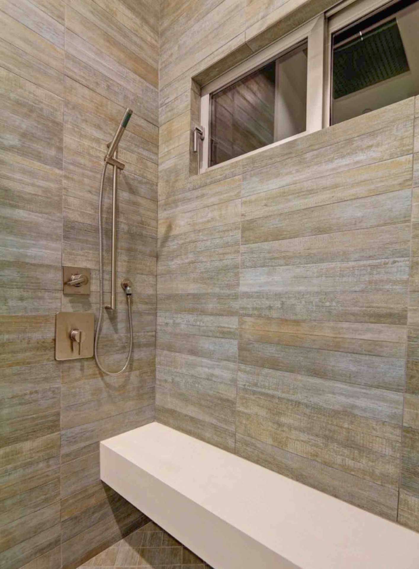 LA walk-in shower with wood-look tile walls, floating bench, and brushed nickel fixtures