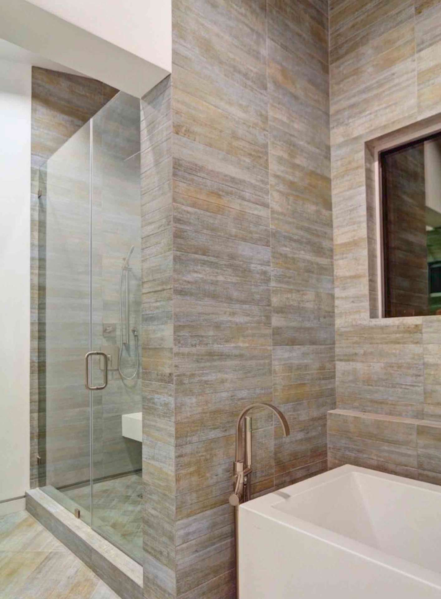LA bathroom with floor-to-ceiling wood tile, glass shower enclosure, and soaking tub