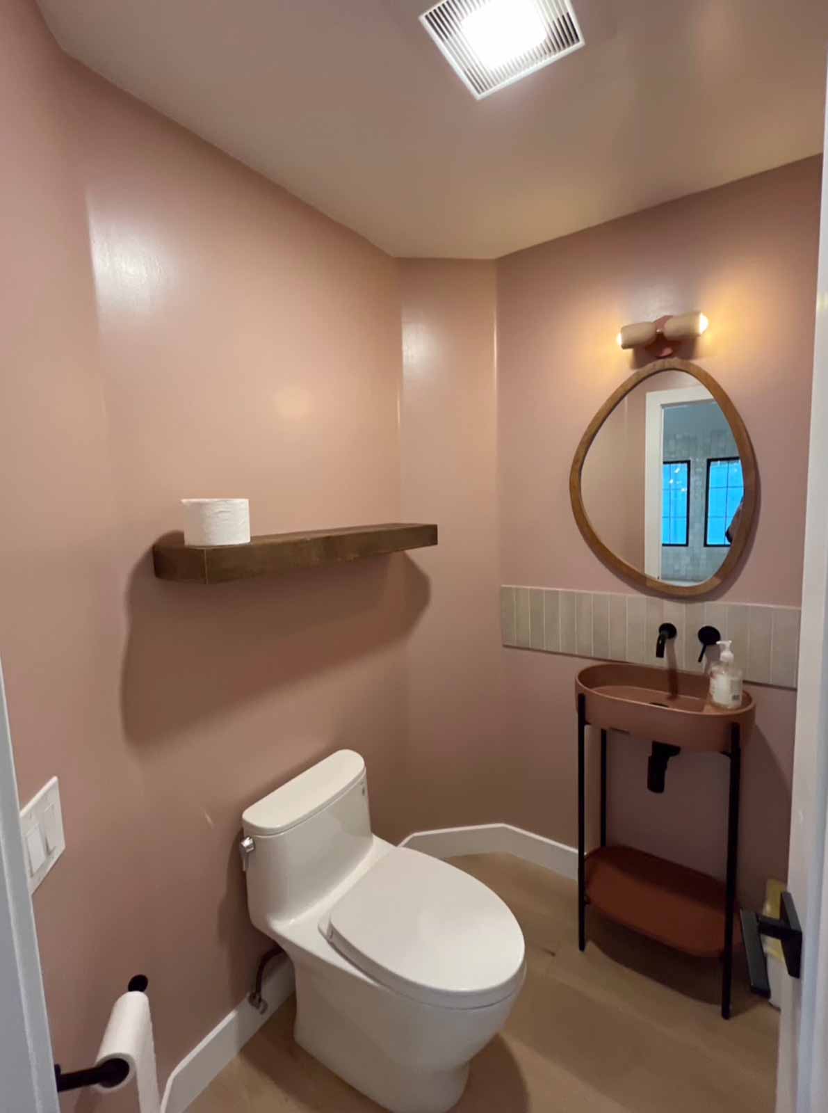 Long Beach powder room with blush pink walls, organic mirror, and terracotta console sink