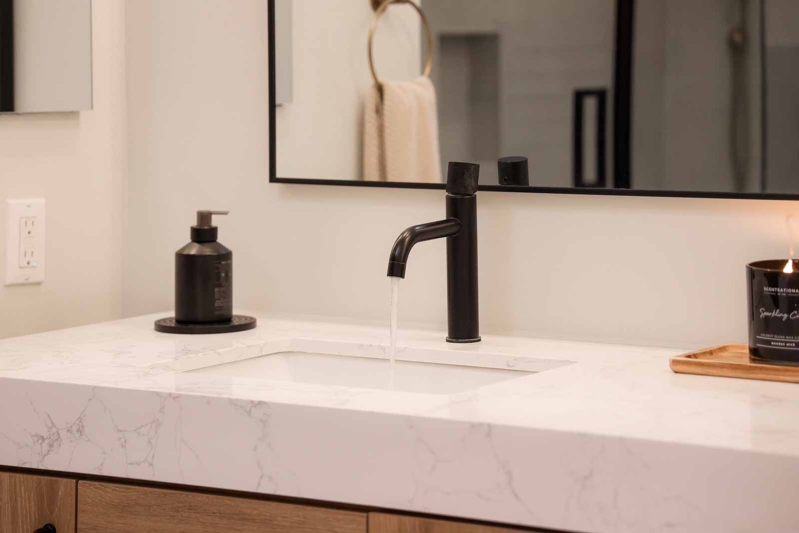 Marble countertop detail with matte black faucet and modern accessories - Long Beach bathroom