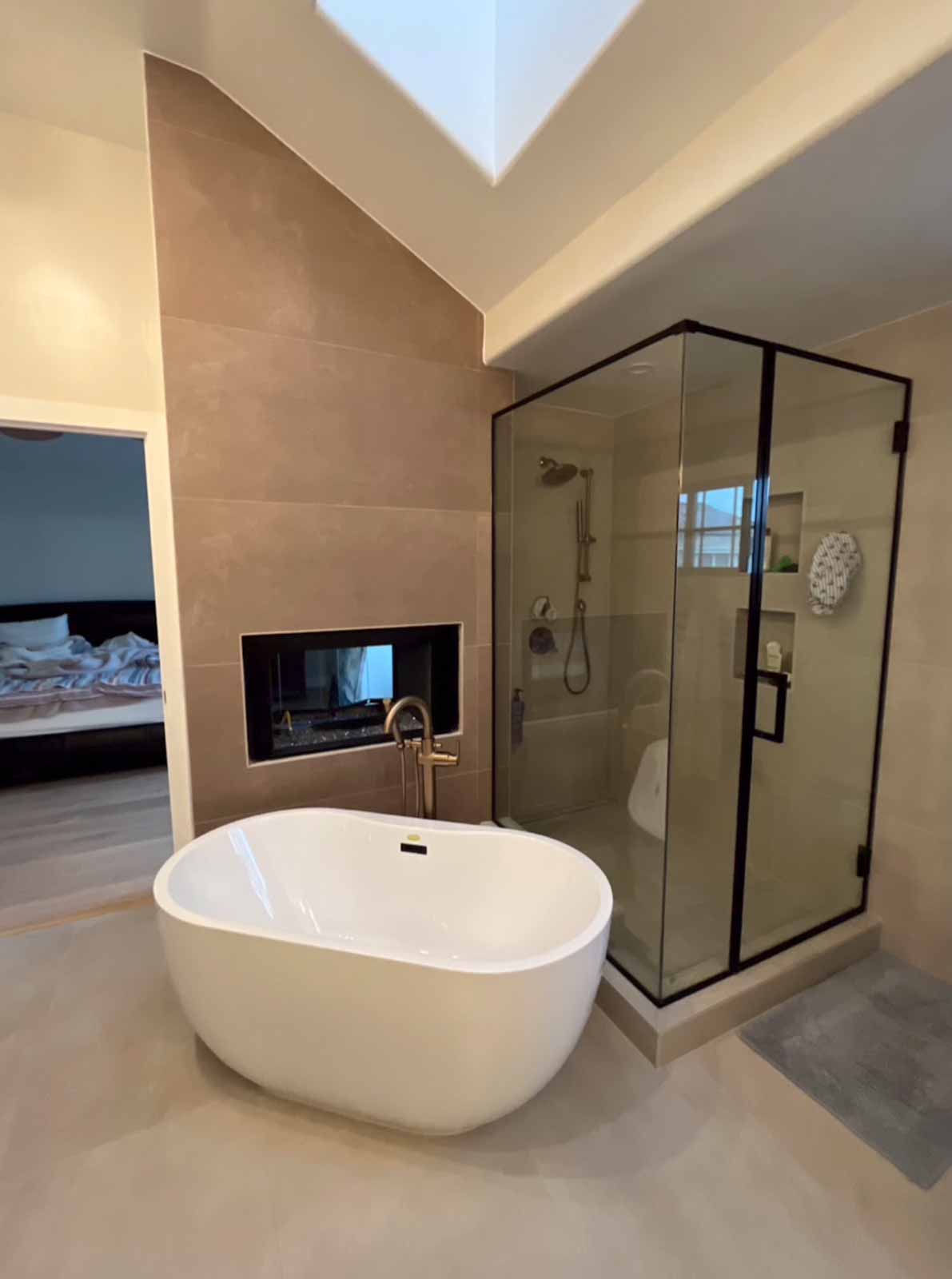 Spa-like bathroom with soaking tub, skylight, and corner glass shower in Long Beach