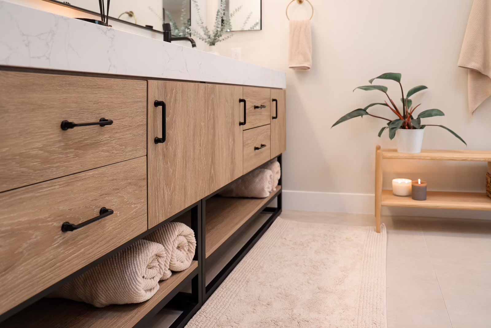 Modern oak vanity with open shelving, towel storage, and decorative plants - Long Beach