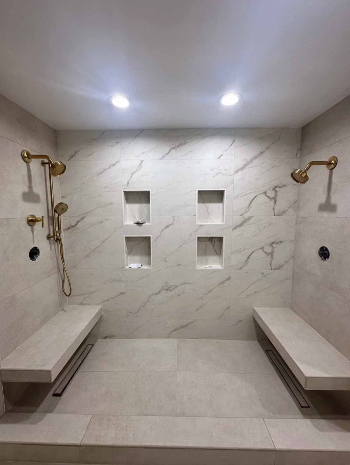 Los Angeles master shower with dual rain heads, marble walls, and built-in niches