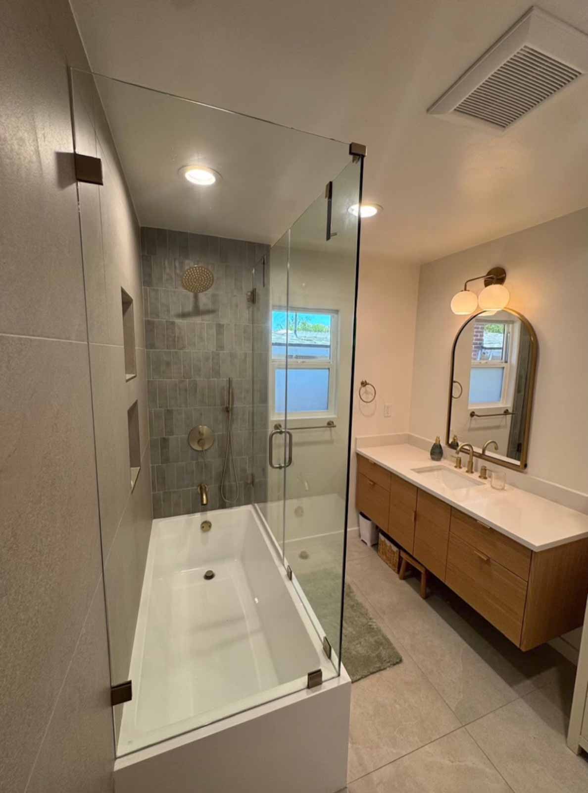 Pasadena bathroom with glass-enclosed tub-shower, gray tile, and floating oak vanity