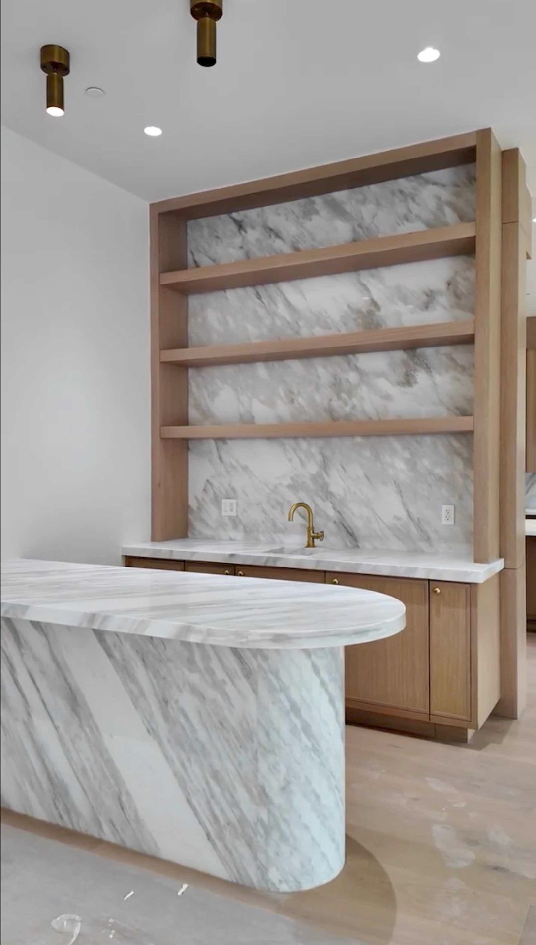 Brentwood kitchen wet bar with marble shelving and brass fixtures