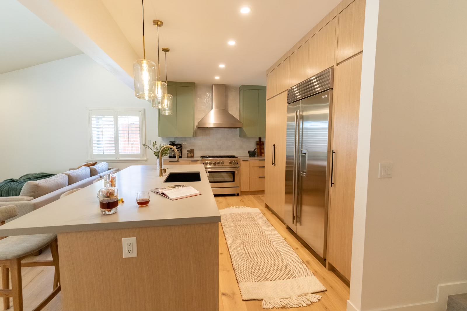Claremont kitchen open concept with sage green cabinets and Sub-Zero refrigerator