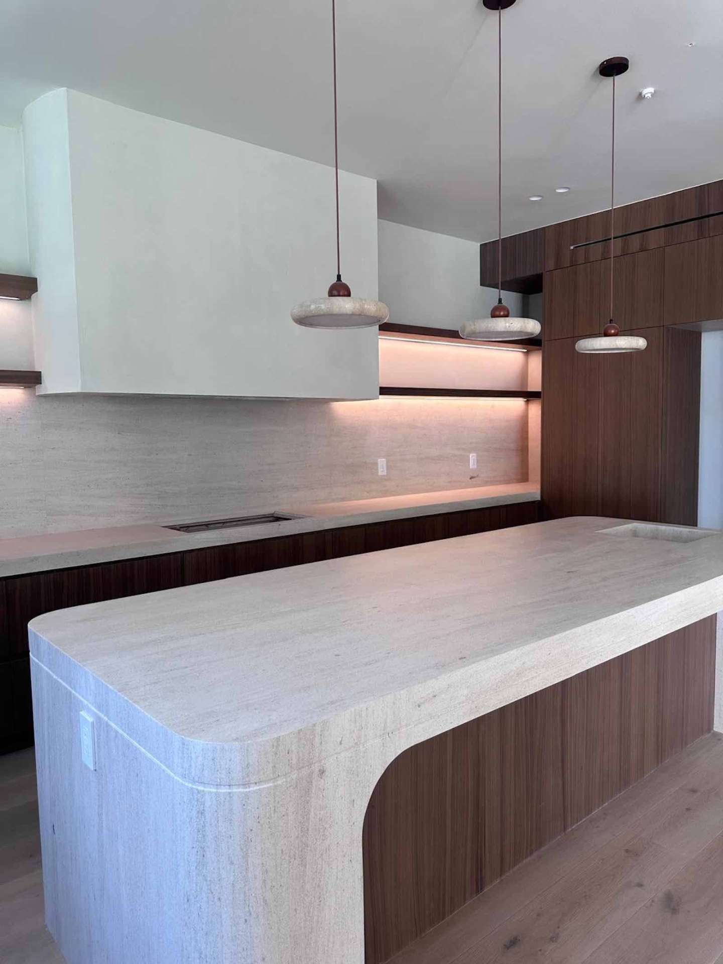 Encino kitchen waterfall travertine countertop with stone pendants