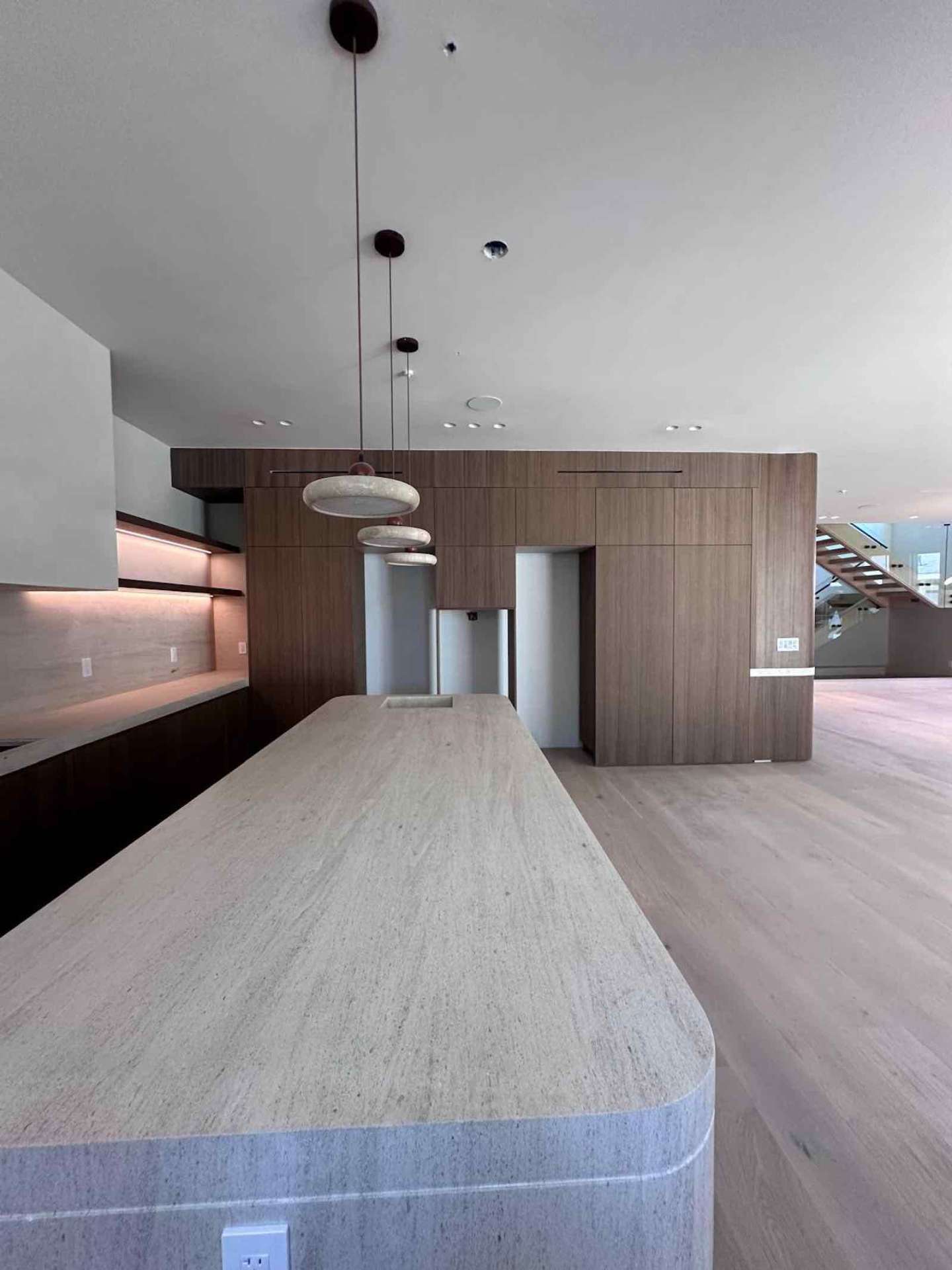 Encino kitchen full view with travertine island and floating staircase