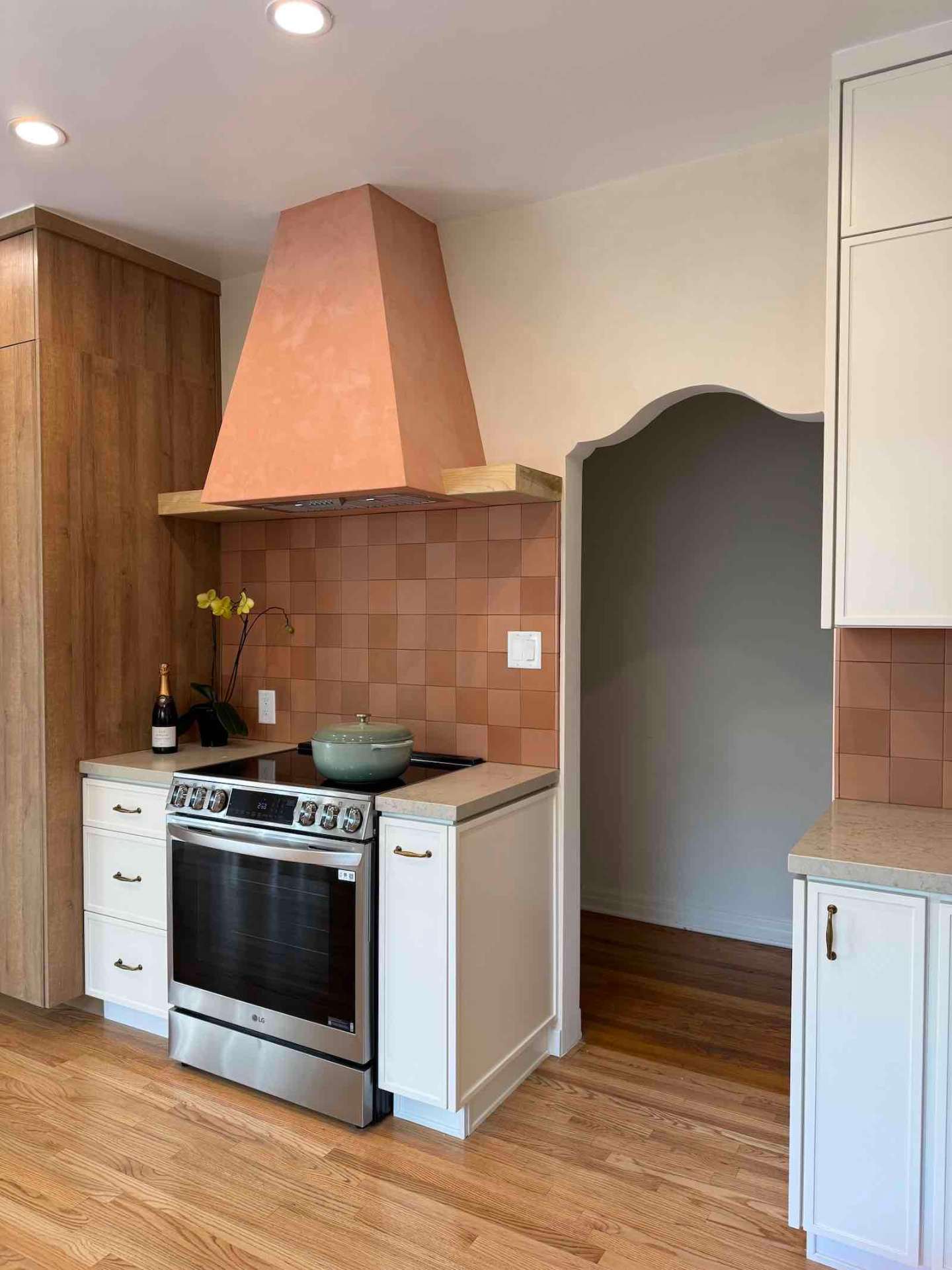 Rancho Park kitchen cooking area with sage archway and two-tone cabinets