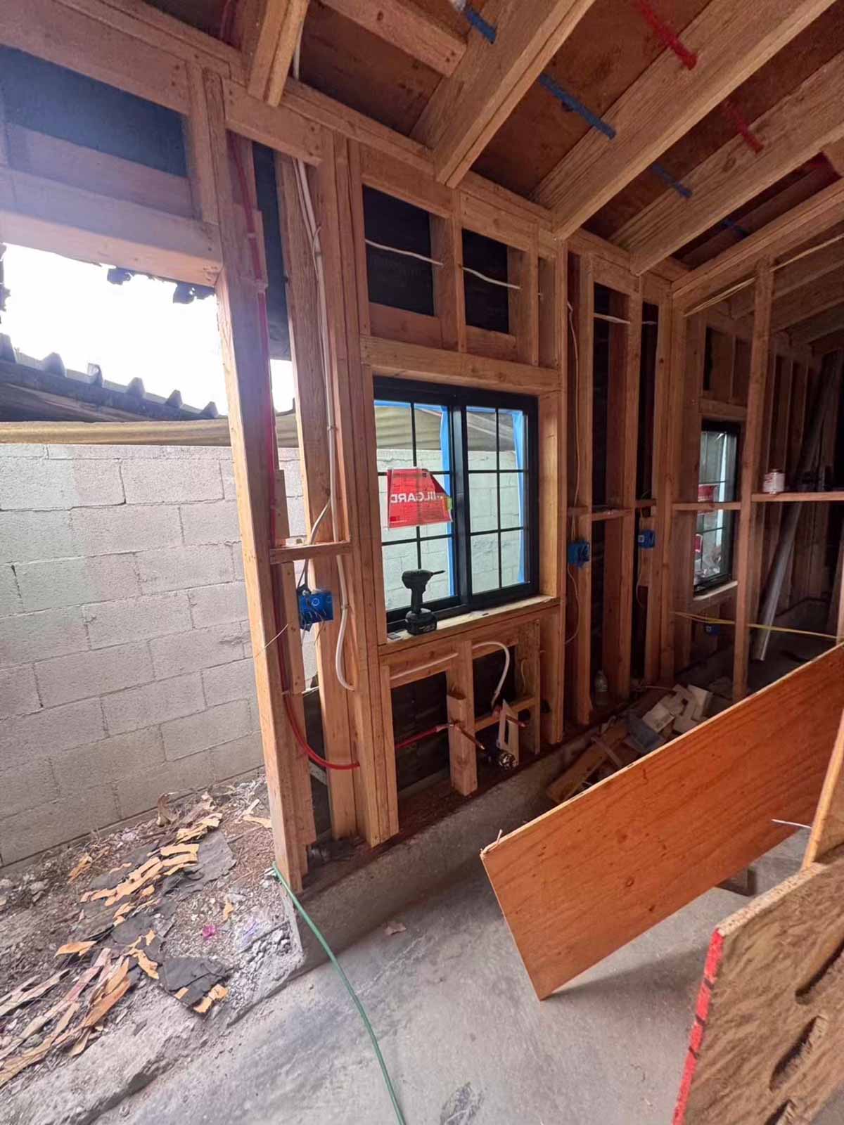 Room addition framing in progress Fulton showing wood studs, electrical rough-in, and window installation - Los Angeles room addition contractor