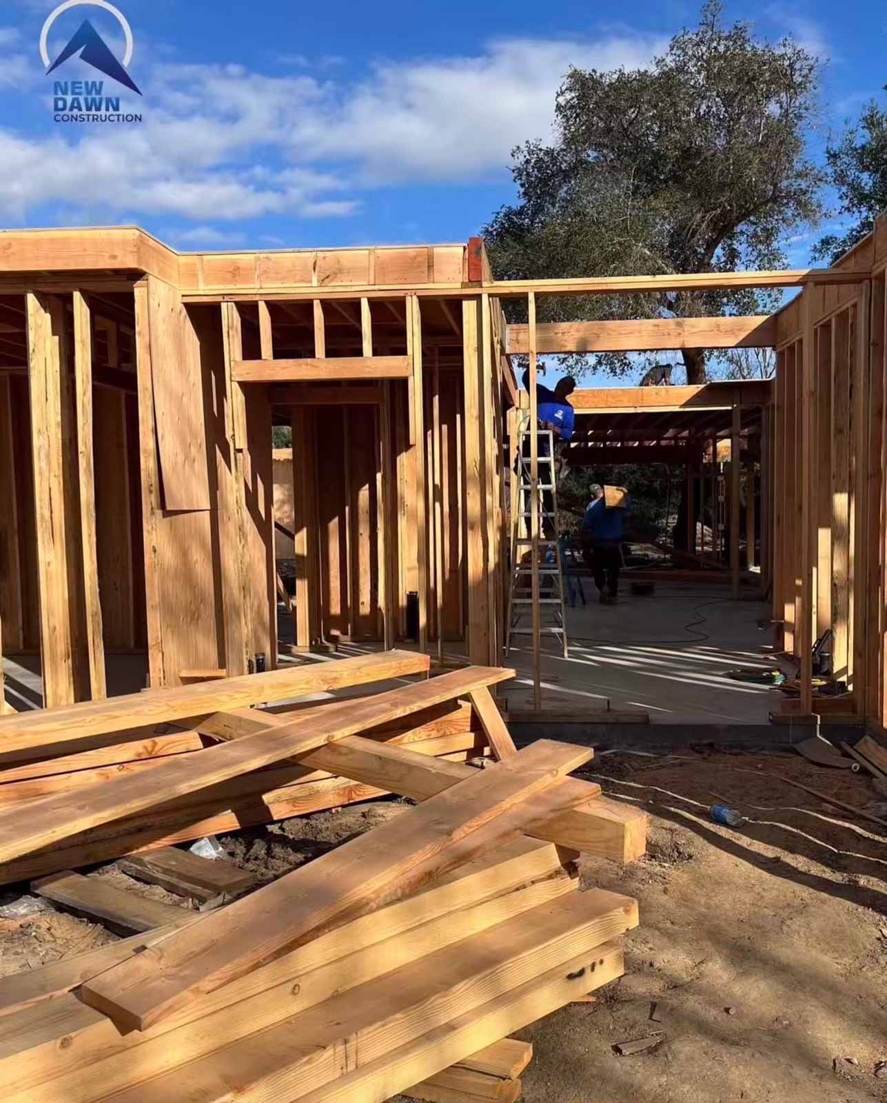 Room addition exterior framing Los Angeles with crew installing roof trusses - professional home expansion